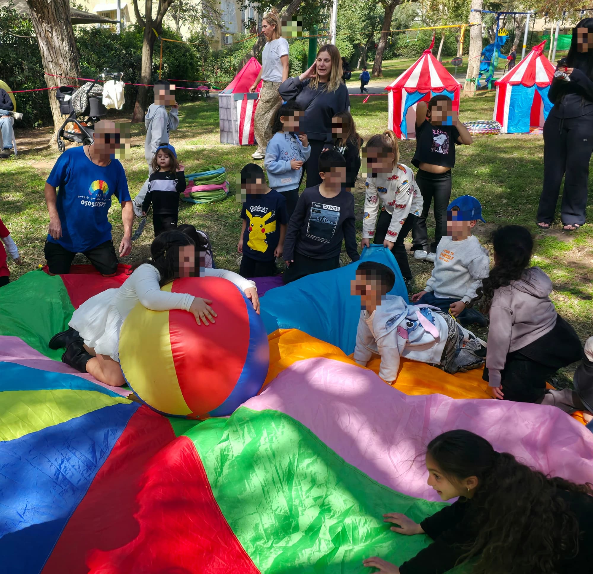 מתחם תחנות הפעלה לילדים של נוני — מצנח צבעוני, כדור ענק ואוהלים בחצר